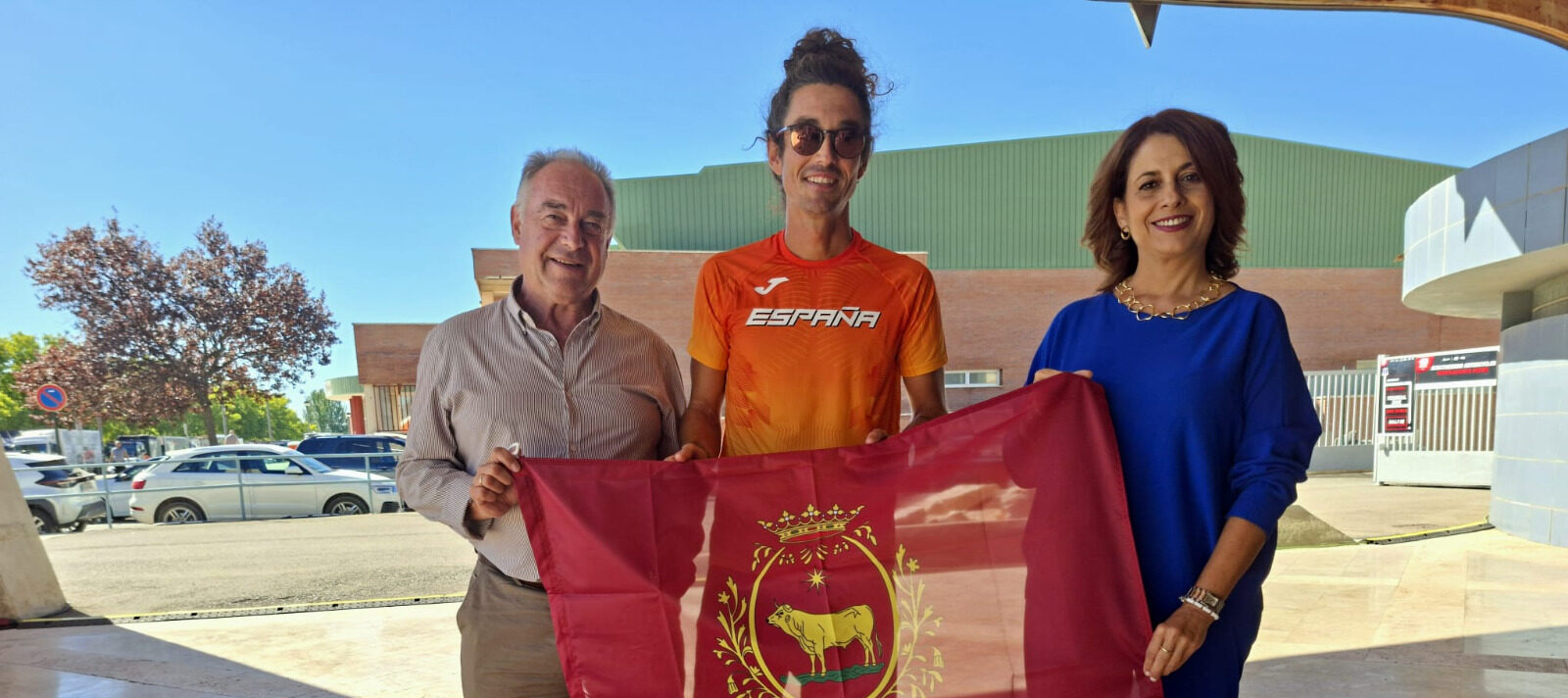 Emma Buj entrega la bandera de Teruel a Marco Álvarez antes de su cita con la élite mundial de los 100 kilómetros